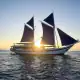 Ombak Putih pinisi ship with sunset background