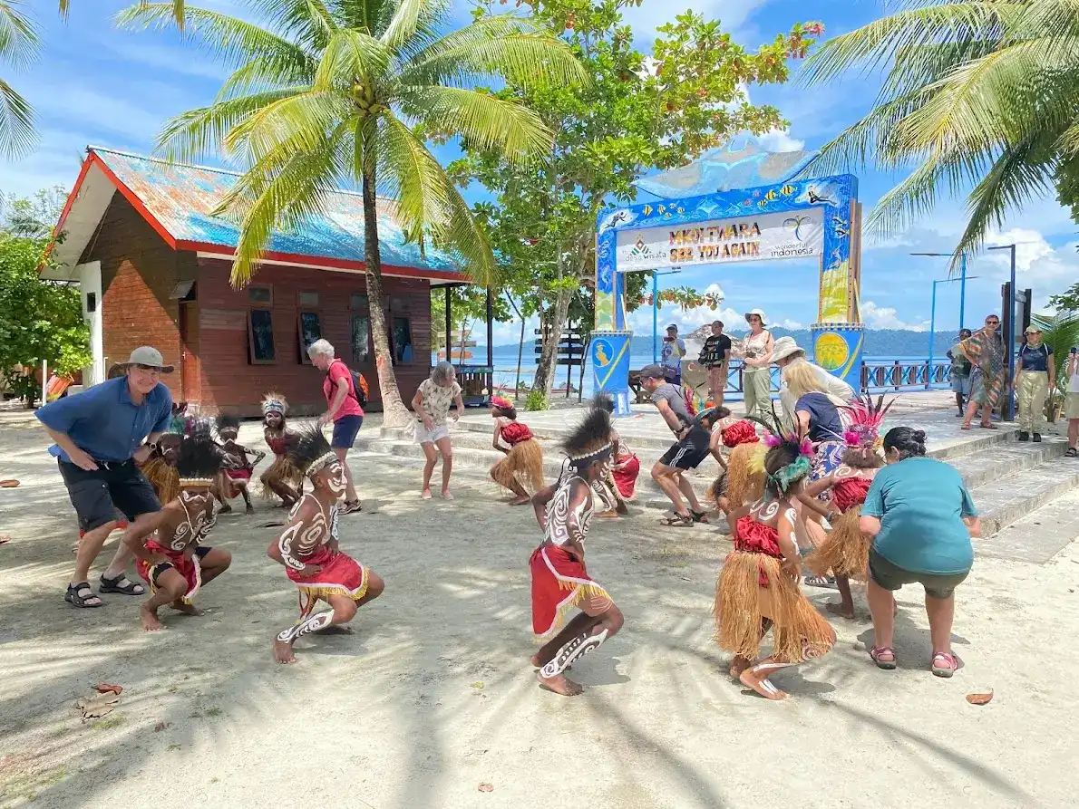 SeaTrek's guest dancing with locals in Raja Ampat
