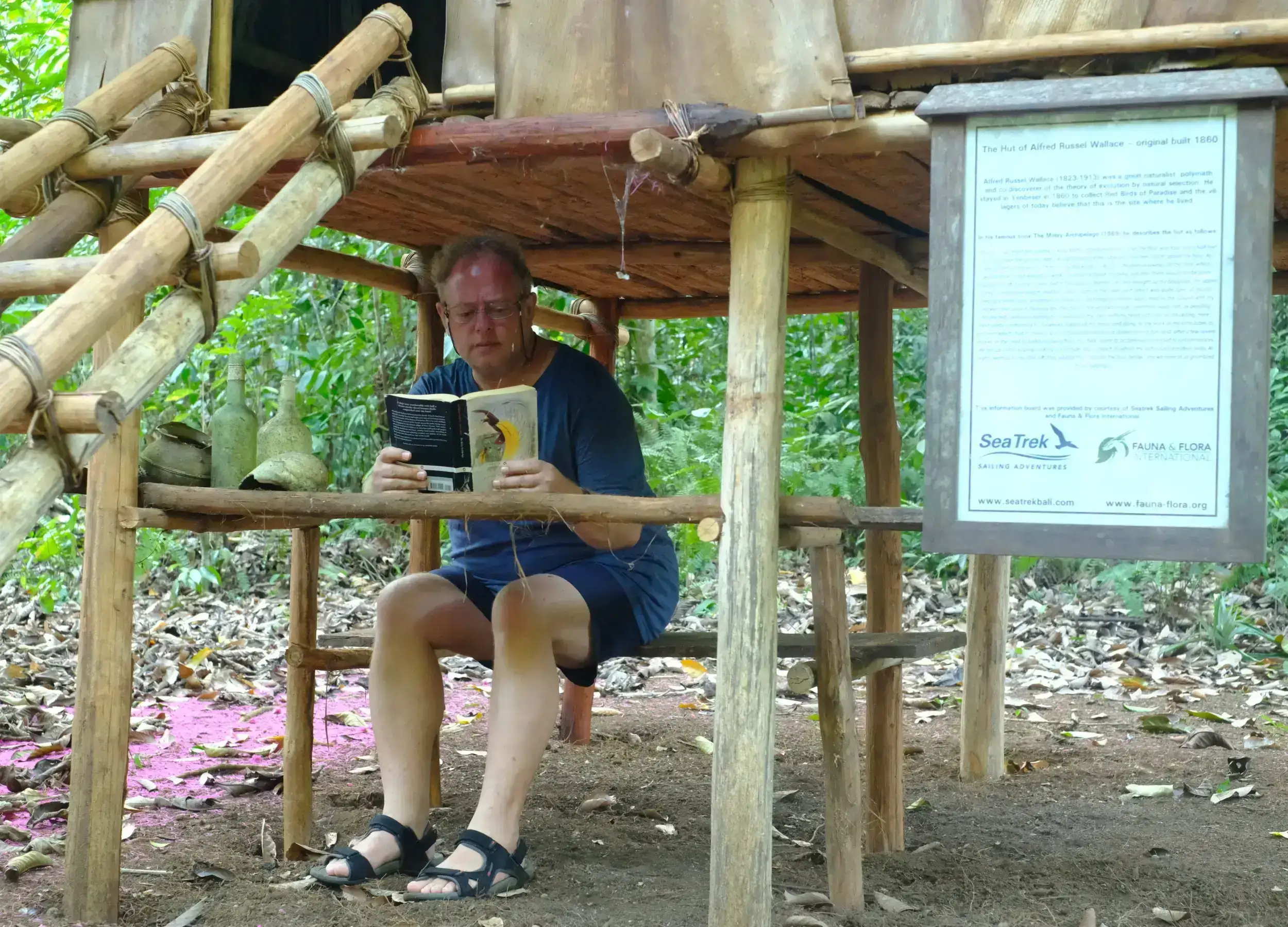 George Beccaloni reading the Malay Archipelago under the Wallace Hut replica in Raja Ampat