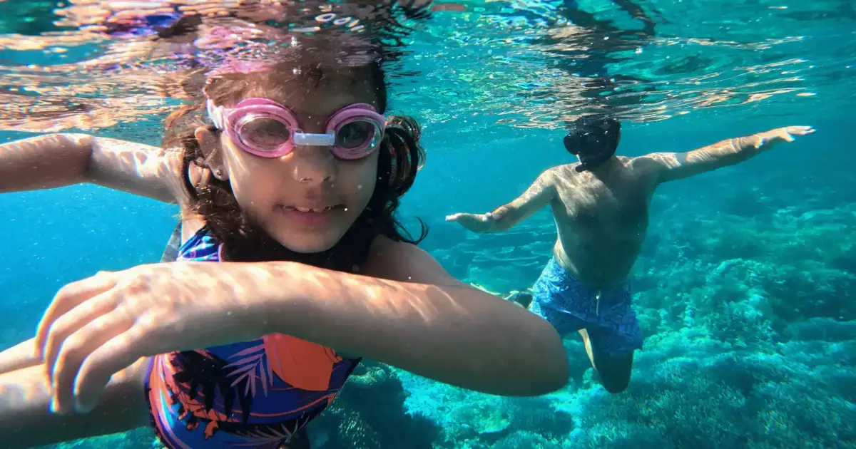 a dad and daughter enjoy family snorkeling trip