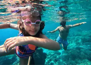 a dad and daughter enjoy family snorkeling trip