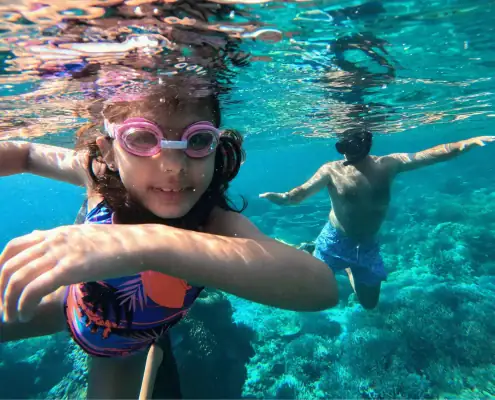 a dad and daughter enjoy family snorkeling trip