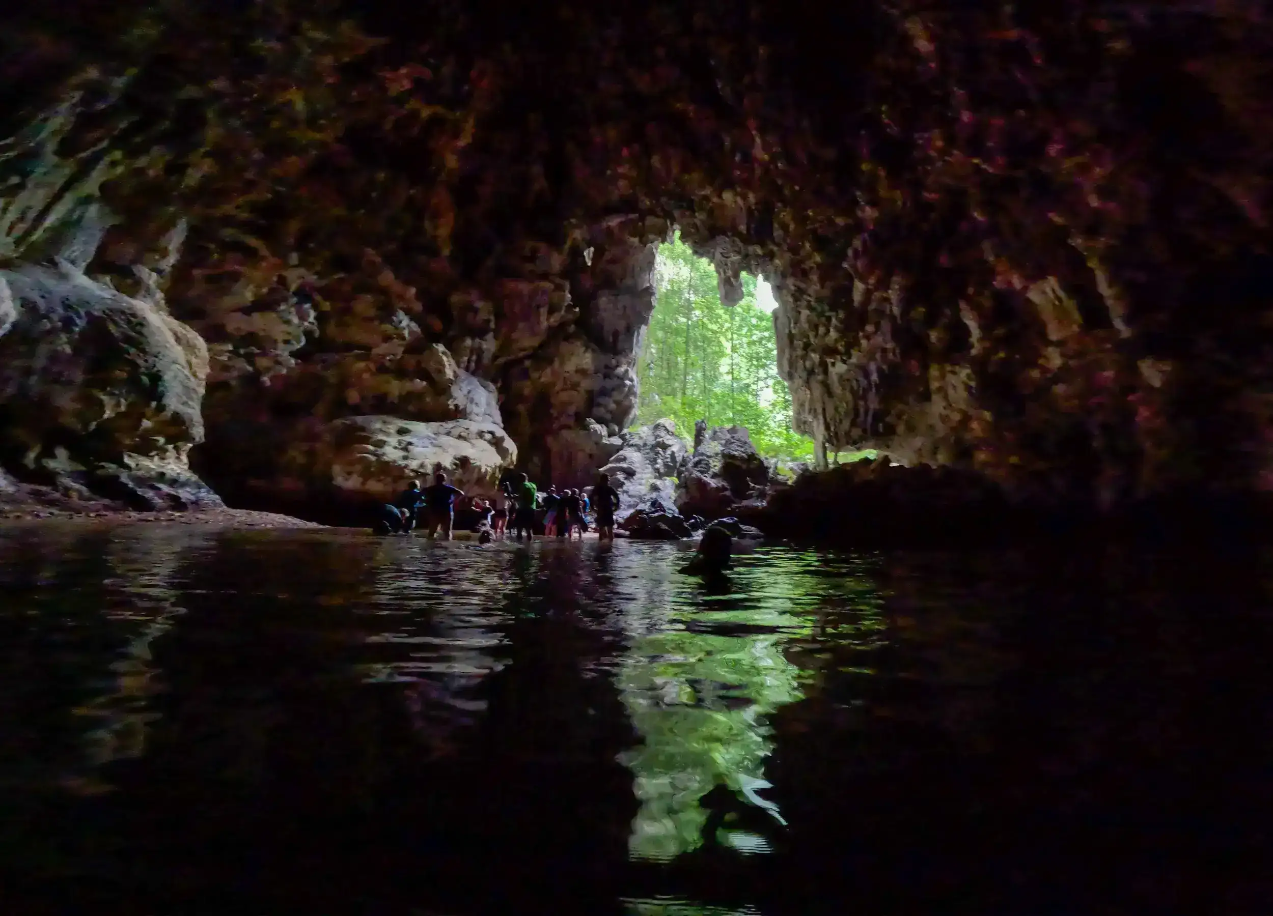 SeaTrek's guests swimming inside the dark cave of Tomolol Raja Ampat